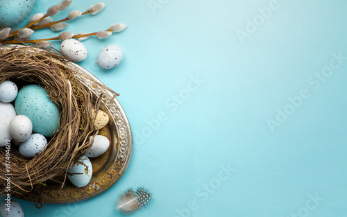  Easter background with Easter eggs and spring flowers on blue table