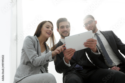Fototapeta Naklejka Na Ścianę i Meble -  three business people are looking at a tablet PC