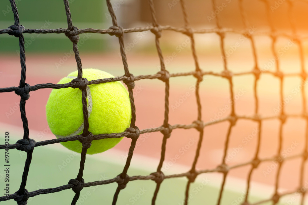 Tennis ball hitting to net on blur tennis court background