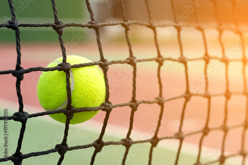 Tennis ball hitting to net on blur tennis court background