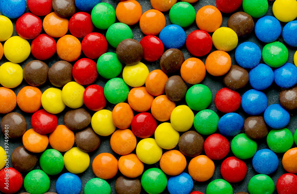 Chocolate candy dragees covered colorful glaze as a background Chocolate candy dragees covered colorful glaze as a background