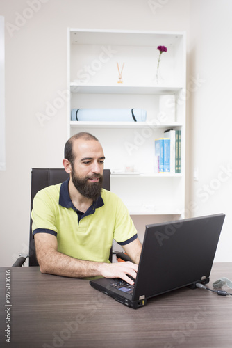physiotherapist using laptop in his clinic