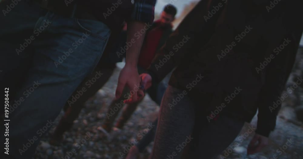 Young couple holding hands while walking on the beach Young couple holding hands while walking on the beach