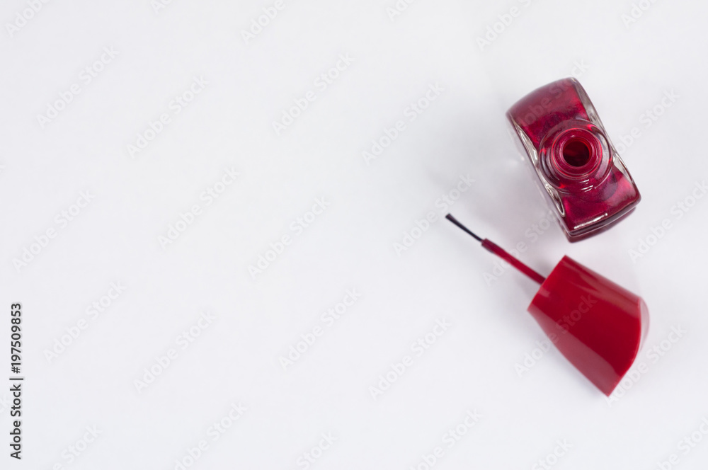 Full new opened glass bottle of shiny red nail polish and brush on white background Full new opened glass bottle of shiny red nail polish and brush on white background