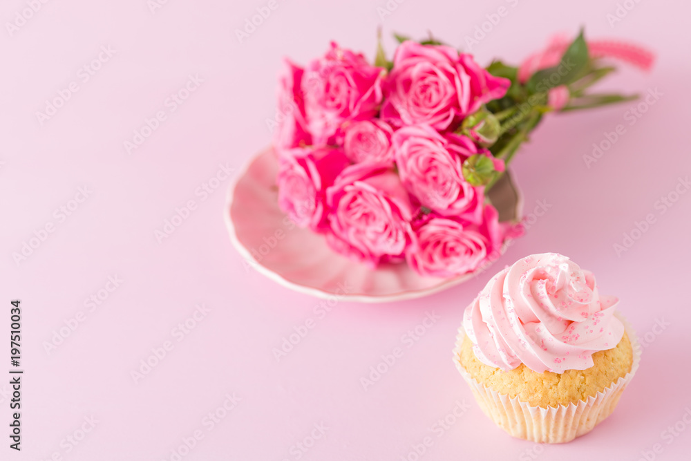Cupcake with pink cream decoration and roses on pink pastel background. Cupcake with pink cream decoration and roses on pink pastel background.