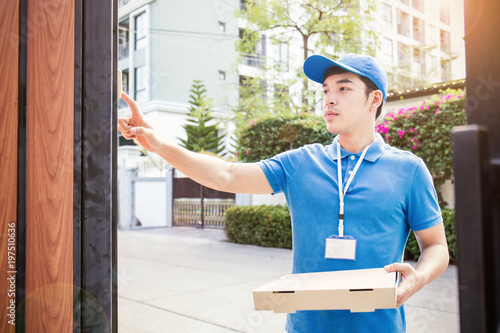 Fotografija Portrait of happy delivery asian man with blue uniform hands holding cardboard