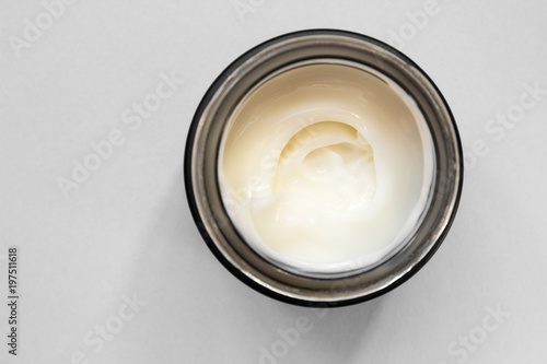 Smear cream with snail mucin in black container. Lotion for face or body. Skin care. Close up