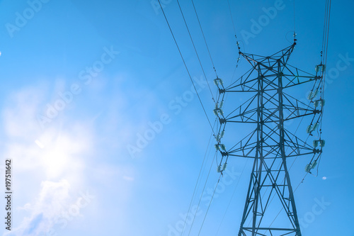 High voltage power line tower on a blue sky background
