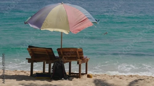 Two chaise longers stand on the background of the ocean photo