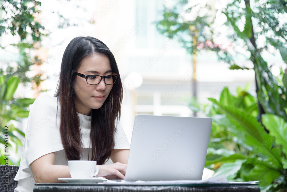 Beautiful asian attractive woman has working and typing on laptop computer for business marketing at coffee cafe in the morning with happy and relaxing time. Beautiful asian attractive woman has working and typing on laptop computer for business marketing at coffee cafe in the morning with happy and relaxing time.