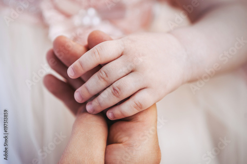 a child's hand holds an adult man