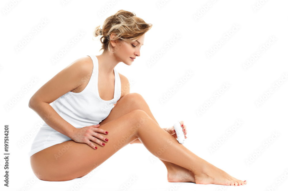 Fototapeta premium Depilation. Woman epilates her leg with an electric epilator device.