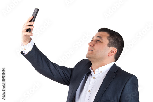 Portrait of a young man dressed in a white shirt and black suit looking at a mobile phone. Isolated on white