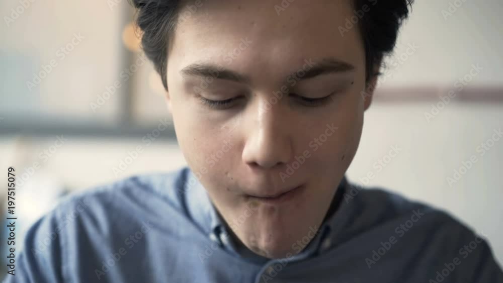 Happy teenager eating hamburger sandwich in fast food bar
Happy teenager eating hamburger sandwich in fast food bar
