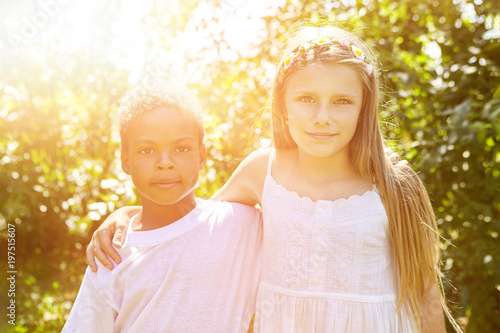 Afrikanischer Junge und blondes Mädchen im Garten photo