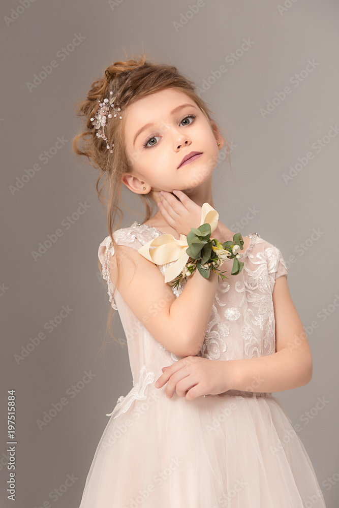 Little pretty girl with flowers dressed in wedding dresses Little pretty girl with flowers dressed in wedding dresses
