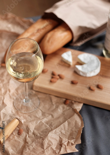 A glass of white wine and cheese on a blackboard