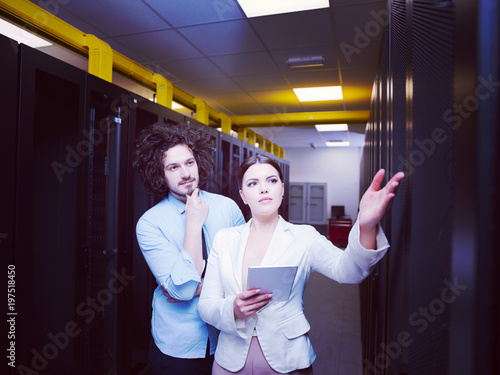 engineer showing working data center server room to female chief