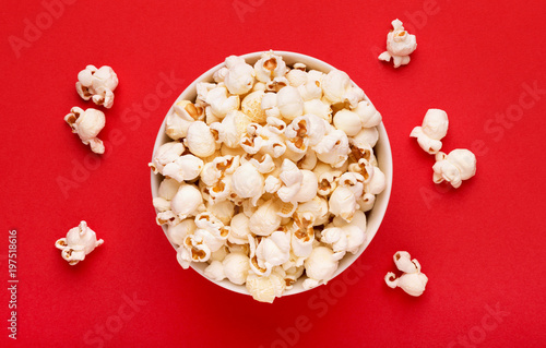 Popcorn viewed from above on a red background. Flat lay of pop corn bowl. Top view