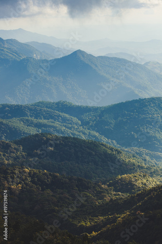 Smoky mountain landscape with mountain and light rays before sunset.