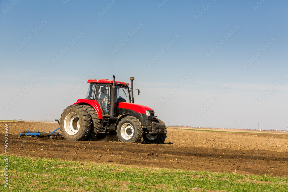 Tractor cultivating field at spring Tractor cultivating field at spring