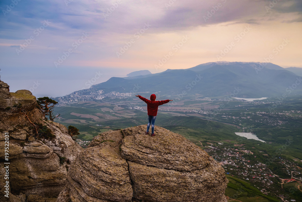 Obraz premium Young woman standing on top of cliff