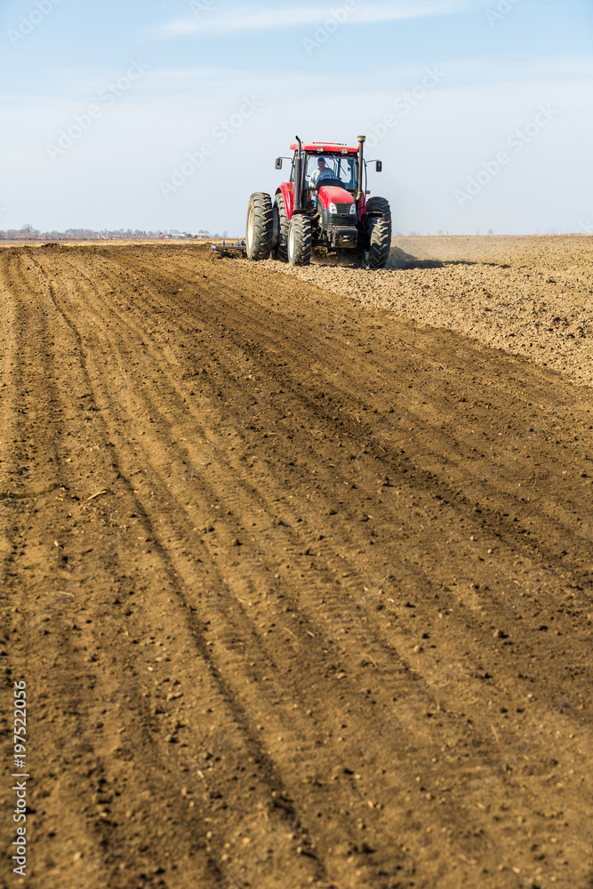 Tractor cultivating field at spring Tractor cultivating field at spring