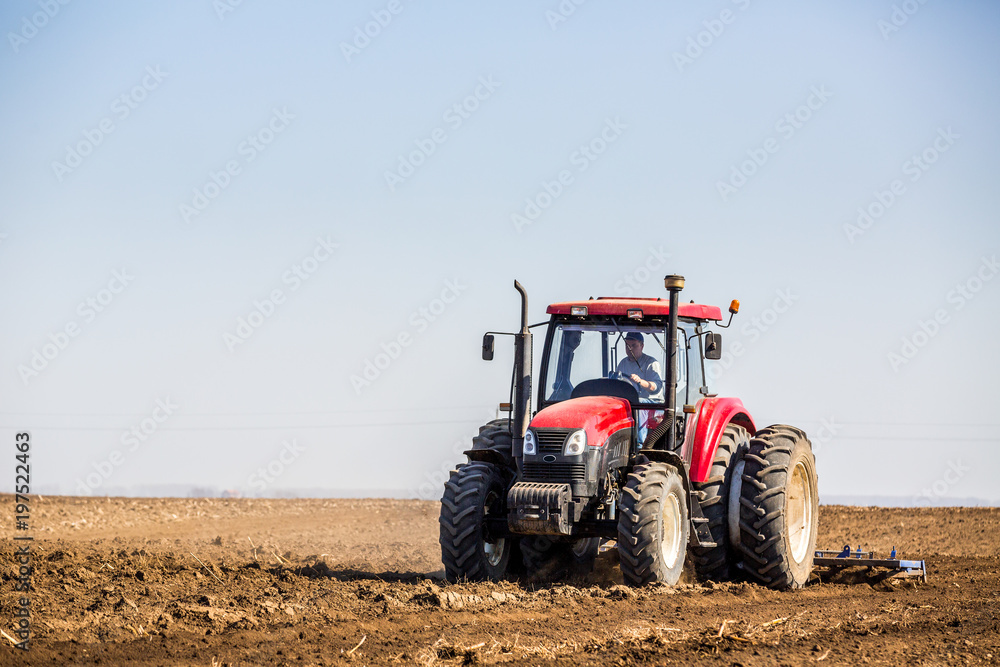 Tractor cultivating field at spring Tractor cultivating field at spring