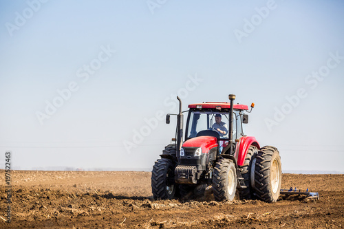 Tractor cultivating field at spring