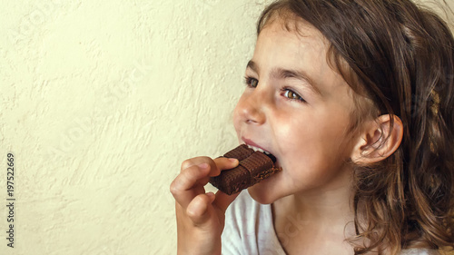 Tanned girl enjoys a slice of milk chocolate