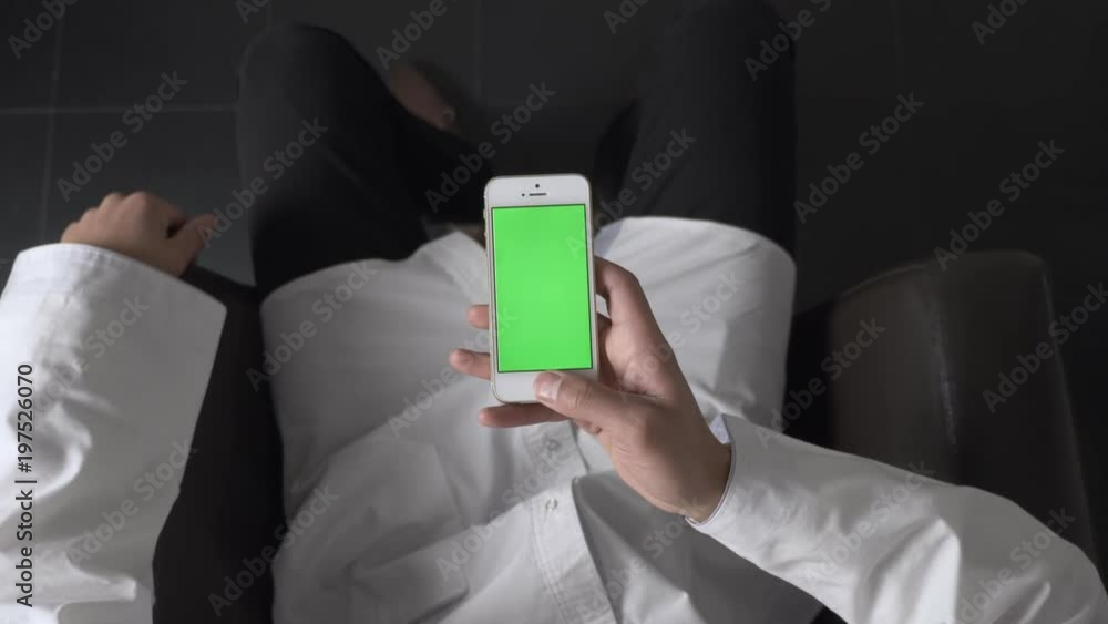 Male African hands using a white smartphone, just holding the smartphone in hand , top shot 60 fps Male African hands using a white smartphone, just holding the smartphone in hand , top shot 60 fps