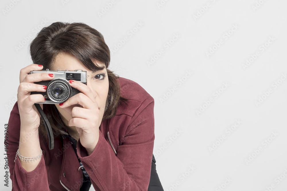 Cute woman taking a photo with a camera on a white background Cute woman taking a photo with a camera on a white background