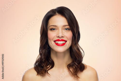 beauty, make up and people concept - happy smiling young woman with red lipstick over beige background