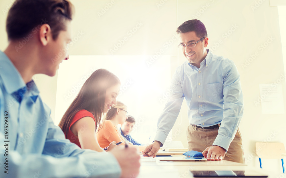 Obraz premium education, school, learning, teaching and people concept - group of students and teacher talking in classroom