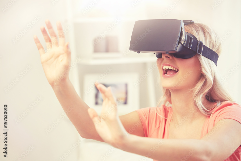 technology, virtual reality, entertainment and people concept - happy young woman with virtual reality headset or 3d glasses playing game at home and touching something invisible technology, virtual reality, entertainment and people concept - happy young woman with virtual reality headset or 3d glasses playing game at home and touching something invisible