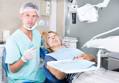 Dentist examining and performing treatment to woman