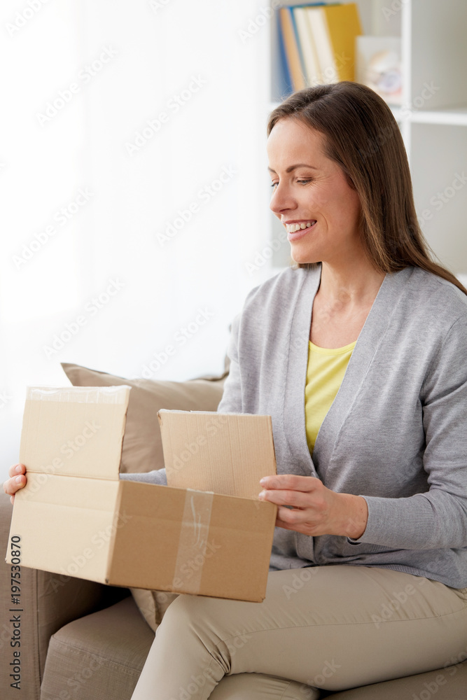 delivery, mail and people concept - smiling middle-aged woman opening parcel box at home delivery, mail and people concept - smiling middle-aged woman opening parcel box at home