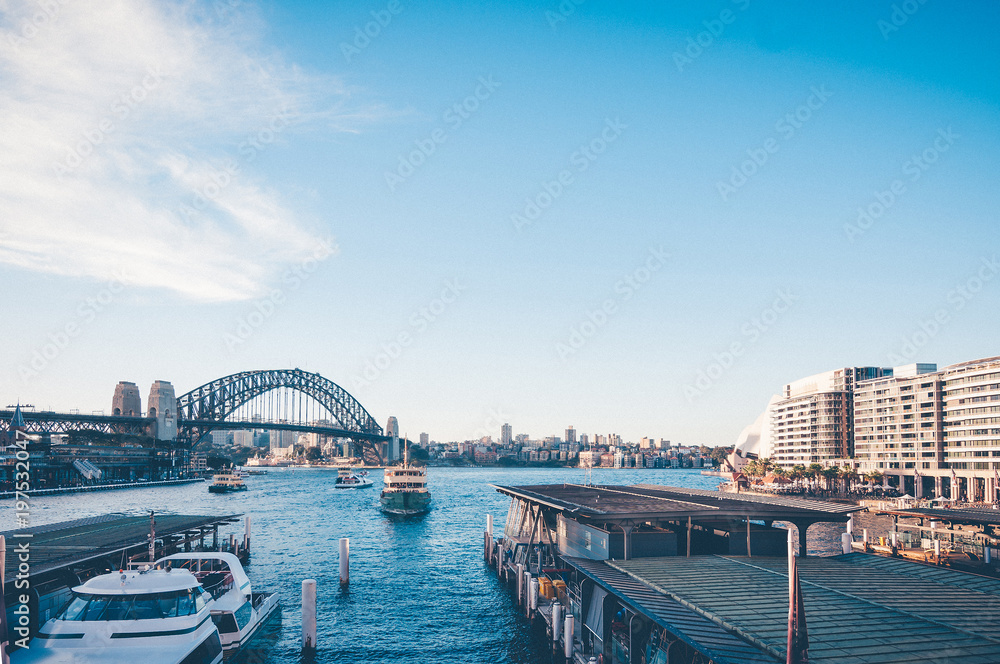Stunning view of the waterfront near the Opera house to Sydney Harbour Bridge and sea pier and passenger boats