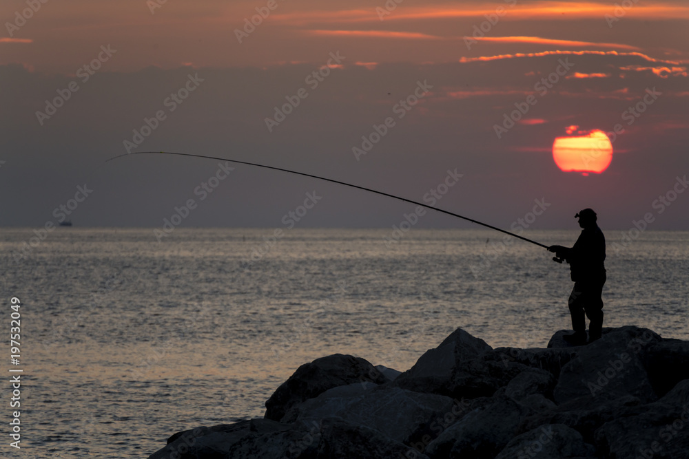 fishing under a sunrise