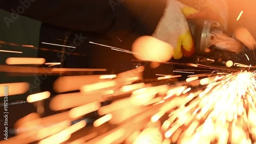 worker grinding weld seam with grinder machine and sparks. Slow motion
