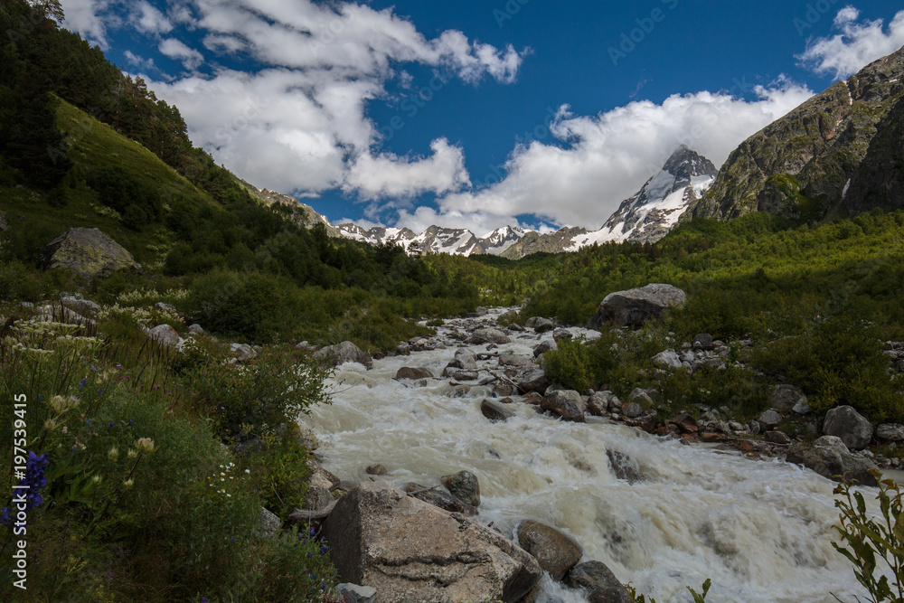 Movement of clouds and water flows in a stormy river in the Caucasus mountains in summer