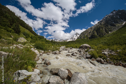 Movement of clouds and water flows in a stormy river in the Caucasus mountains in summer