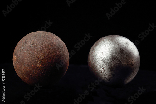 Two metal balls on a black background.