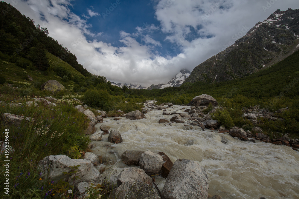 Movement of clouds and water flows in a stormy river in the Caucasus mountains in summer Movement of clouds and water flows in a stormy river in the Caucasus mountains in summer
