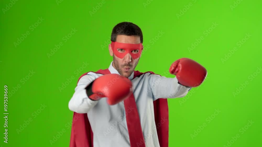 Superhero with boxing gloves against green background Superhero with boxing gloves against green background