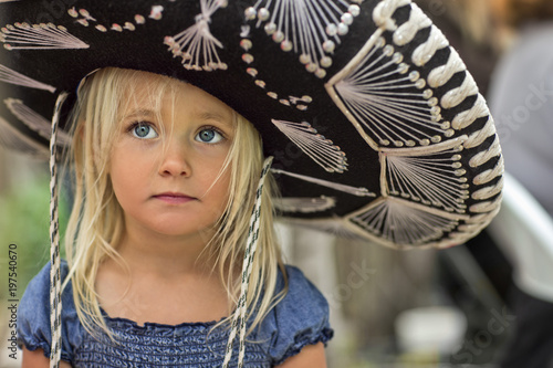 Girl in sombrero standing outdoors