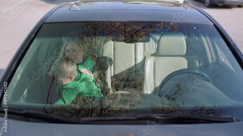 Little boy sitting in the car with his young mother 4k