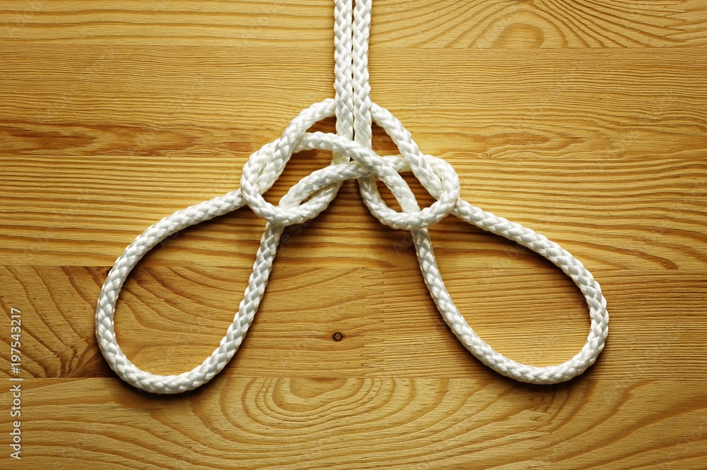 Rope with knot on a wood background