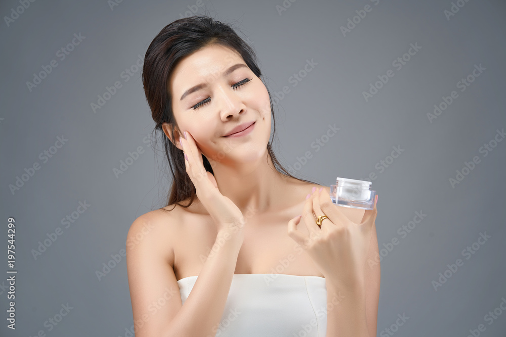 Happy beautiful asian girl with the fresh skin in grey colour background. Expressive facial expressions. Cosmetology and Spa concept. Happy beautiful asian girl with the fresh skin in grey colour background. Expressive facial expressions. Cosmetology and Spa concept.