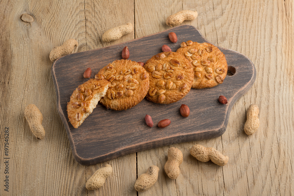 Fototapeta premium Peanut biscuits with nuts and cocoa powder. Top view, on a wooden texture